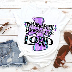 May include: White t-shirt with a purple cross design and the text "For the battle belongs to you LORD".