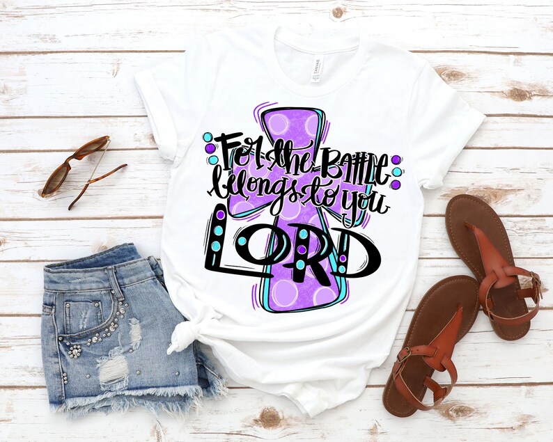 May include: White t-shirt with a purple cross design and the text "For the battle belongs to you LORD".