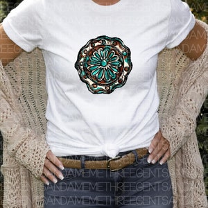 K&ouml;nnte beinhalten: Ein wei&szlig;es T-Shirt mit einem t&uuml;rkisfarbenen und braunen Mandala-Design. Das Mandala hat ein florales Muster mit einer zentralen Blume.