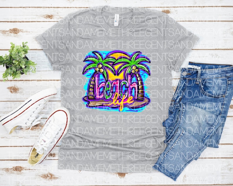 Pu&ograve; includere: Una maglietta grigia con un design grafico colorato di palme e il testo "Beach Life".