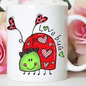 K&ouml;nnte beinhalten: Wei&szlig;e Keramiktasse mit einem roten Marienk&auml;fer-Design und dem Text "Love bug" in schwarzer und gr&uuml;ner Schrift. Der Marienk&auml;fer hat schwarze Punkte und rosa-wei&szlig; gestreifte Herzen.