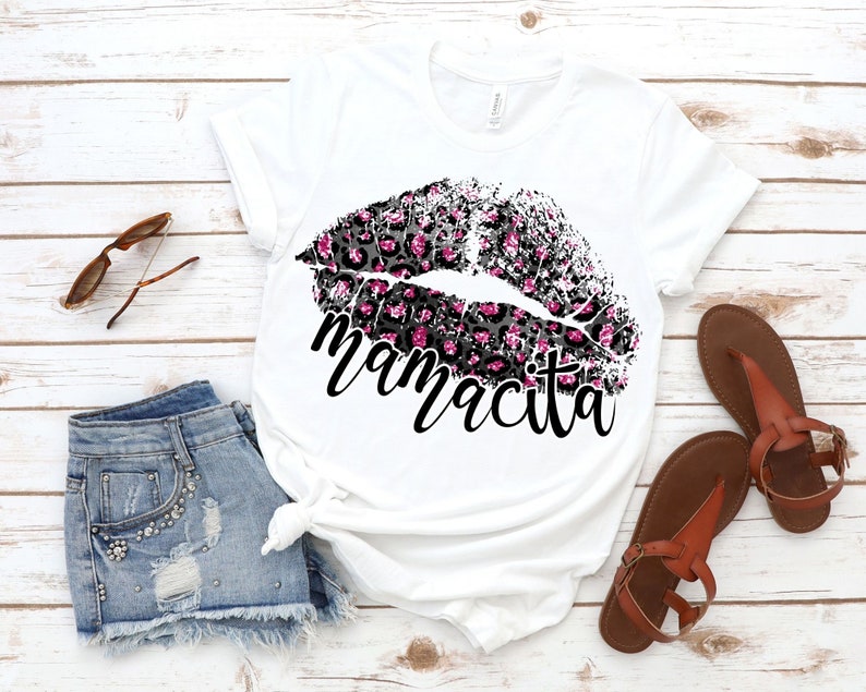 Pu&ograve; includere: Maglietta bianca con un design a labbra con stampa leopardata rosa e nera e la parola "mamacita" stampata sotto.