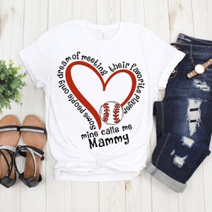 May include: White t-shirt with a red heart and baseball graphic. The text reads "I dream of meeting some people only mine calls me Mammy. Their favorite player"