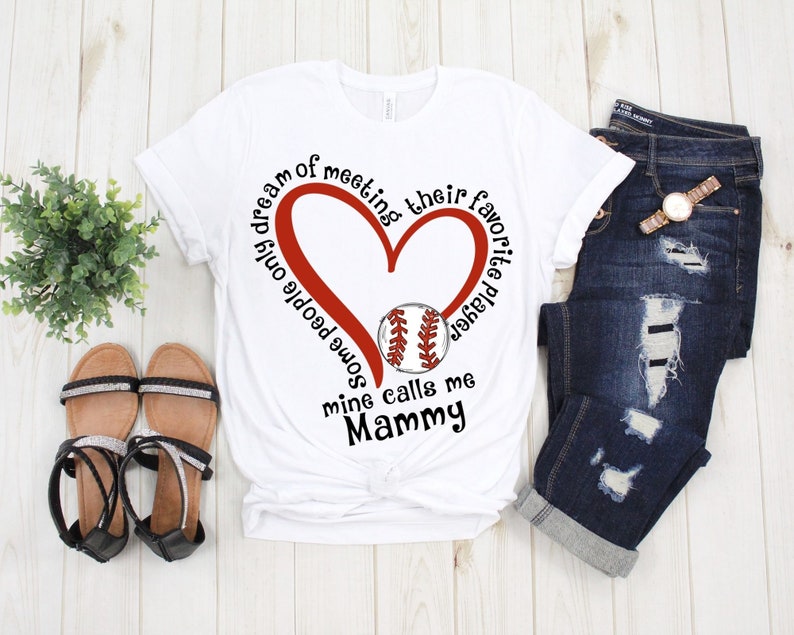 May include: White t-shirt with a red heart and baseball graphic. The text reads "I dream of meeting some people only mine calls me Mammy. Their favorite player"