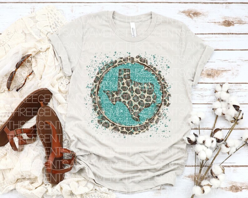 May include: A white t-shirt with a turquoise and brown graphic of the state of Texas with a leopard print design.