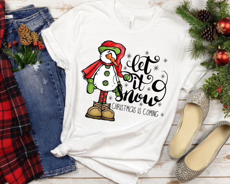 May include: White t-shirt with a snowman graphic and the text "Let it snow, Christmas is coming".
