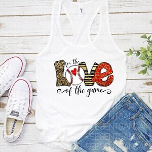 May include: White tank top with a graphic of the word "love" made of baseballs, leopard print, and stripes. The text "for the love of the game" is written below the graphic.