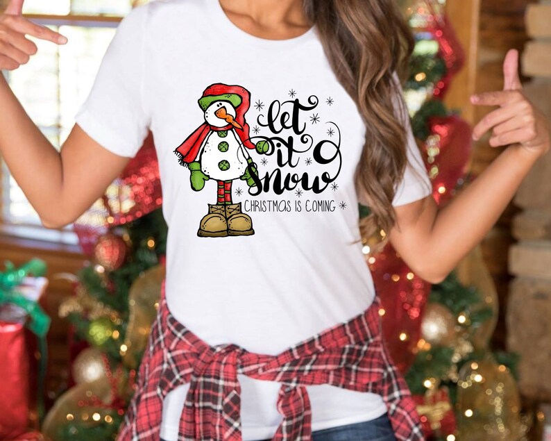 May include: White t-shirt with a snowman graphic and the text "Let it snow" with a smaller text "Christmas is coming".