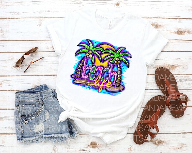 Pu&ograve; includere: Maglietta bianca con un design grafico colorato di palme e il testo "beach life".