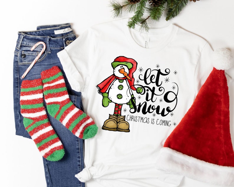 May include: White t-shirt with a snowman graphic and the text "Let it snow. Christmas is coming."