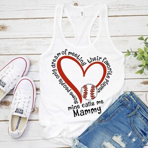 May include: White tank top with a red heart and baseball graphic. The text reads "Some people only dream of meeting their favorite baseball player, mine calls me Mammy."