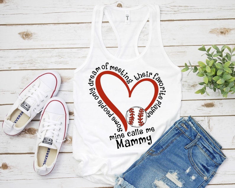 May include: White tank top with a red heart and baseball graphic. The text reads "Some people only dream of meeting their favorite baseball player, mine calls me Mammy."