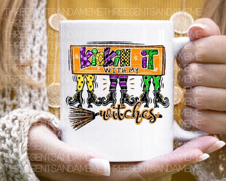 May include: White ceramic mug with a colorful graphic of three witches with broomsticks and the text "Kickin' it with my witches".