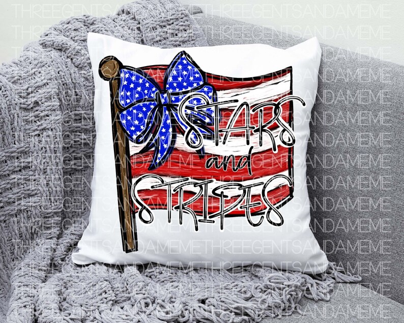 May include: White pillow with a red, white, and blue American flag design. The flag has a blue bow with white stars and the words "Stars and Stripes" written in white.