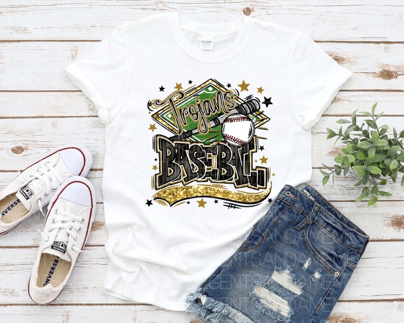 May include: White t-shirt with a green and gold baseball graphic that says "Trojans Baseball".