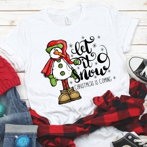 May include: White t-shirt with a snowman graphic and the text "Let it snow" with the words "Christmas is coming" below.