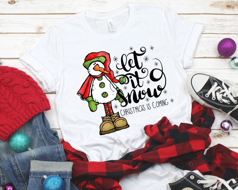 May include: White t-shirt with a snowman graphic and the text "Let it snow" with the words "Christmas is coming" below.