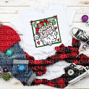 May include: White t-shirt with a red and green illustration of Santa Claus with the text "Merry Christmas" above him.