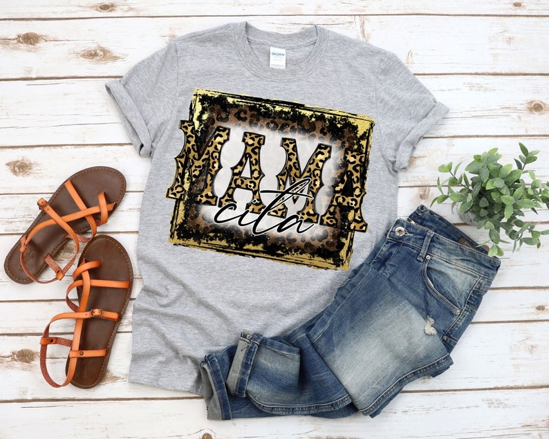 May include: Grey t-shirt with a gold and black square graphic featuring the text "Mamacita" in leopard print.