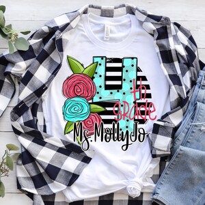 May include: White t-shirt with a black and white striped background, a blue and pink floral design, and the text "4th Grade Ms. Molly Jo".