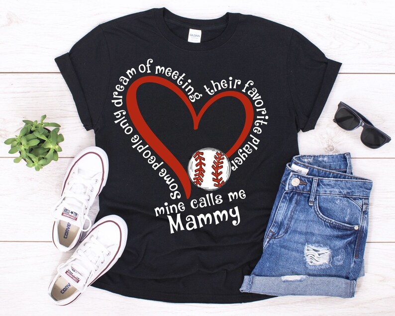 May include: Black t-shirt with a red heart and a baseball graphic. The text on the shirt reads "Some people only dream of meeting their favorite player, mine calls me Mammy."