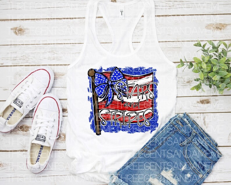 May include: White tank top with a red, white, and blue American flag design. The flag has a blue bow on top and the text "Stars and Stripes" in white letters.