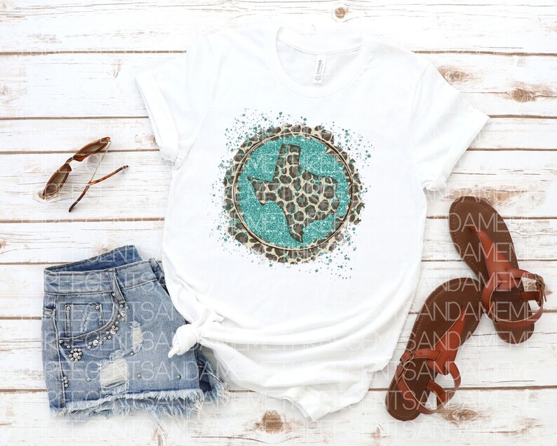 May include: White t-shirt with a turquoise Texas state outline inside a circle of brown leopard print with white paint splatters.