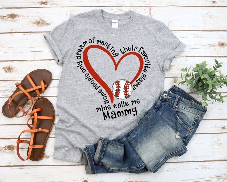 May include: Gray t-shirt with a red heart and a baseball graphic. The text on the shirt reads "Some people only dream of meeting their favorite player, mine calls me Mammy."