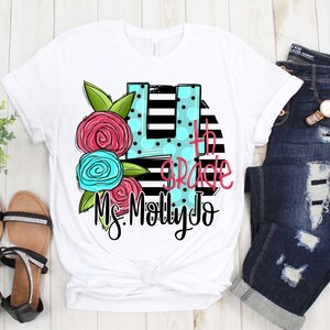 May include: White t-shirt with a black and white striped design featuring a large number 4 with polka dots and the text "4th grade Ms. Molly Jo" in pink and blue lettering. The number 4 is decorated with pink and blue flowers.
