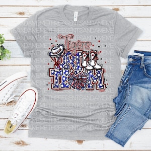 May include: Grey t-shirt featuring a red, white and blue graphic that reads "Tigers Drill Team". The graphic includes a cheerleader, pom-poms and a hat.