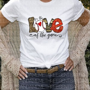 May include: White t-shirt with a graphic design of the word "love" with a baseball and the text "for the love of the game".
