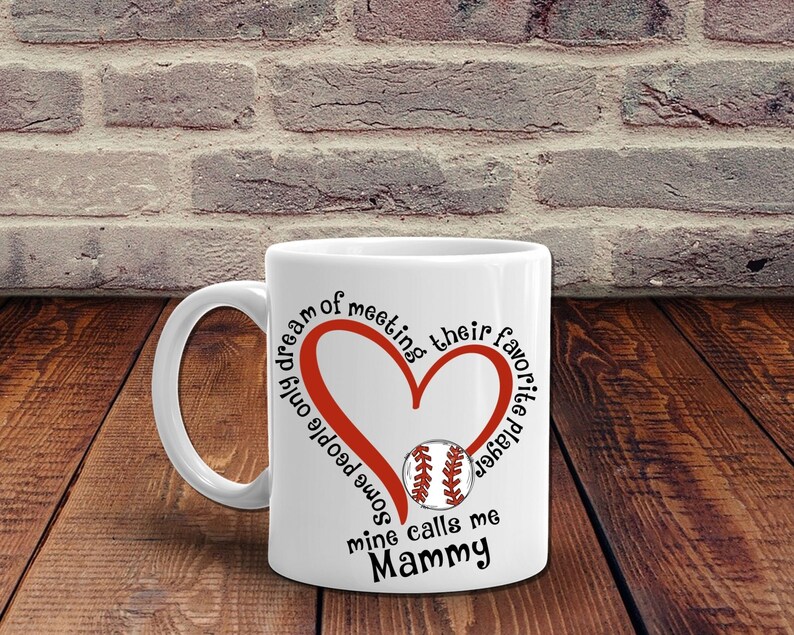 May include: White ceramic mug with a red heart and baseball graphic. The text reads "Some people only dream of meeting their favorite baseball player, mine calls me Mammy."