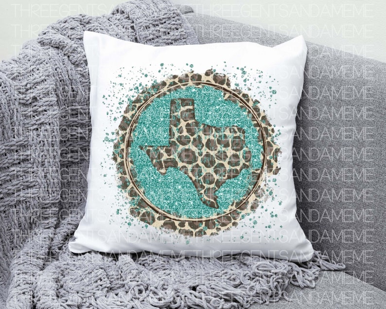 May include: A white pillow with a turquoise and brown glitter design of the state of Texas. The design is surrounded by a white splatter pattern.