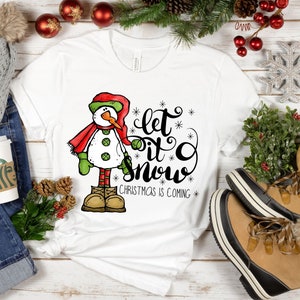 May include: White t-shirt with a snowman graphic and the text "Let it snow. Christmas is coming."