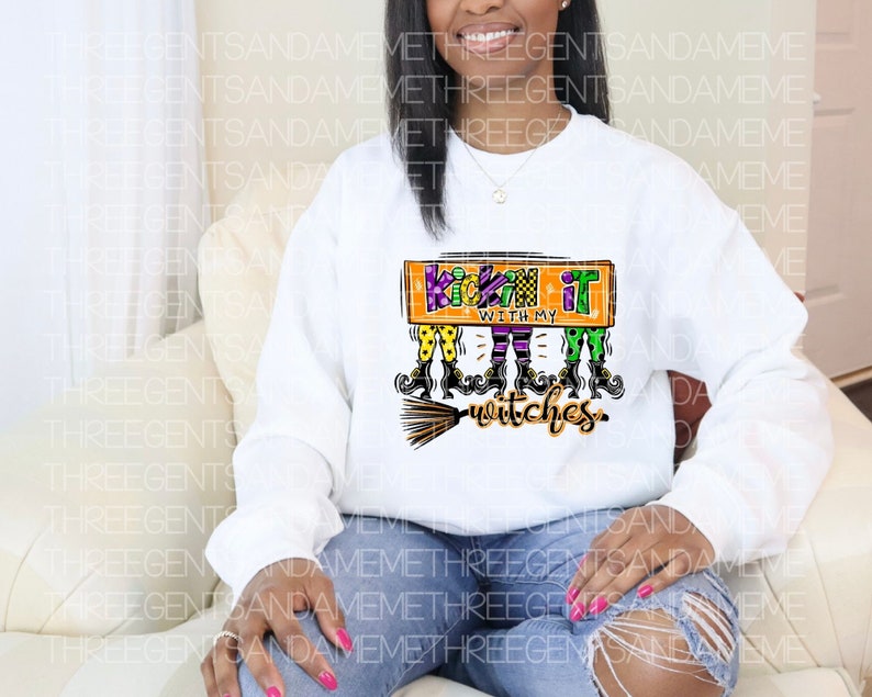 May include: White sweatshirt with a graphic of witches with the text "Kickin' it with my witches".