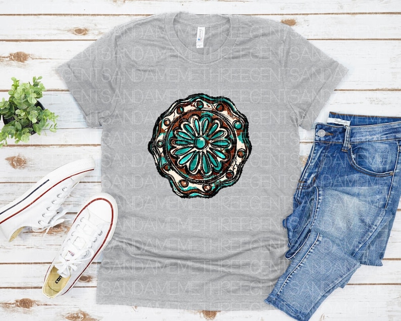 K&ouml;nnte beinhalten: Ein graues T-Shirt mit einem t&uuml;rkisfarbenen und braunen Mandala-Design. Das Mandala hat ein blumenartiges Muster mit filigranen Details.