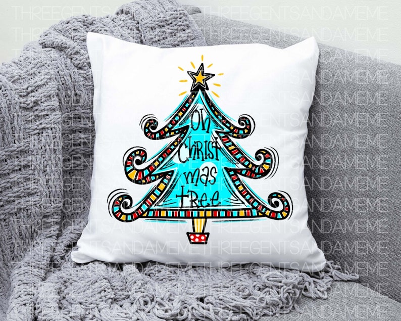 May include: White cushion with a colourful, hand-drawn Christmas tree design. The tree is blue and decorated with red, yellow and black stripes. The text "Oh Christ mas tree" is written on the tree.