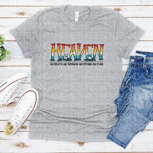May include: A gray t-shirt with a rainbow-colored graphic that says "HEAVEN" and "NO DEATH-NO SORROW-NO CRYING-NO PAIN".