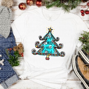May include: White t-shirt featuring a blue, red, yellow and black Christmas tree design. The tree has the words "Oh Christ mas Tree" written on it.