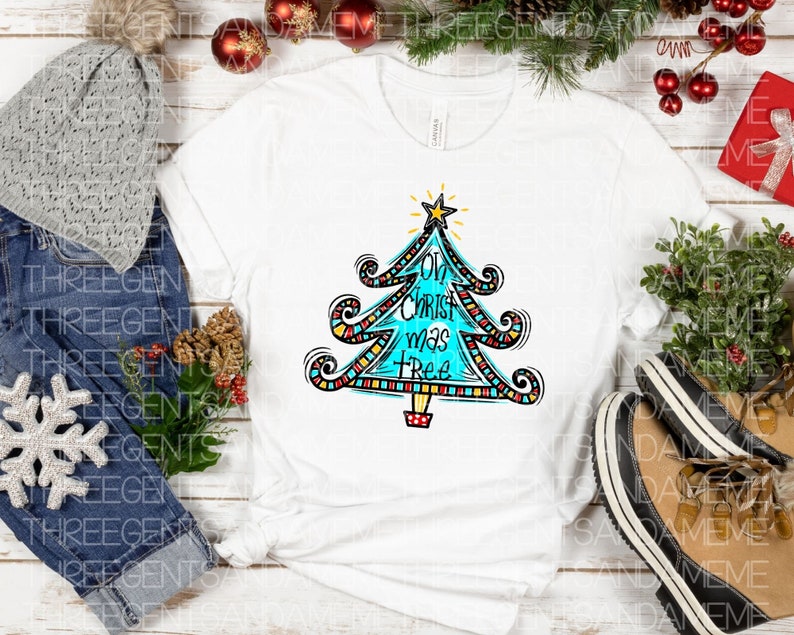 May include: White t-shirt featuring a blue, red, yellow and black Christmas tree design. The tree has the words "Oh Christ mas Tree" written on it.