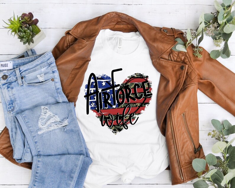 May include: White t-shirt with a red, white, and blue heart design with the words "Air Force Wife" in black text.