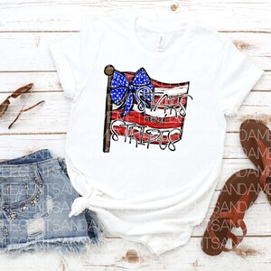 May include: A white t-shirt with a red, white, and blue American flag design. The flag has a blue bow on top and the text "Stars and Stripes" written on it.