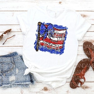 May include: White t-shirt with a distressed American flag design featuring a blue bow and the text "Stars and Stripes".
