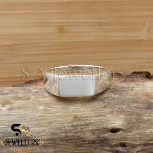 May include: A silver signet ring with a rectangular white stone.