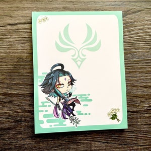 May include: A green and white illustrated card with a chibi anime character holding a staff. The character has purple hair, green eyes, and is wearing a purple and white outfit. The card has a green and white floral design and a green and white symbol in the top center.