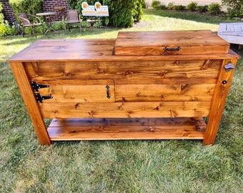 Beautiful, hand built, rustic cedar cooler with bar area, storage area with door, storage shelf and casters.