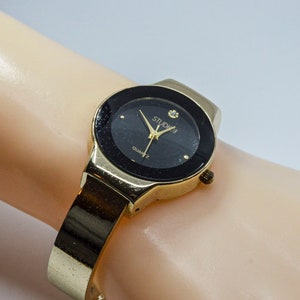 Gold and black tone womens cuff watch