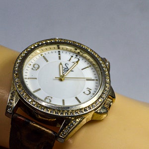 Gold tone with white dial and crystals womens fashion watch
