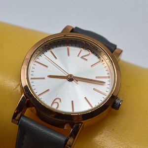 Gold tone with silver dial, gray bracelet , womens watch