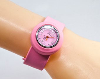 Pink tone womens , childrens wrist watch on adjustable ,flexible bracelet